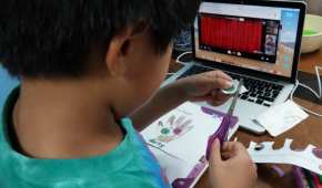 Un niño hace tareas escolares con ayuda de plataformas digitales