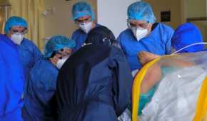Un grupo de médicos y enfermeras atiende a un paciente con COVID-19