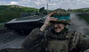 Un soldado de Ucrania se agarra el casco mientras viaja a bordo de un APC en Bájmut